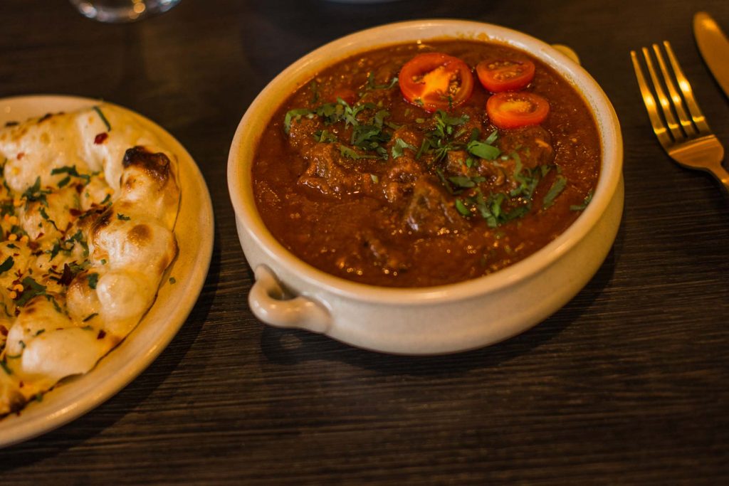 Bowl of Indian curry dish with Bread Naan | Kings XI | Indian Restaurant | Indian Food in Hamlinton