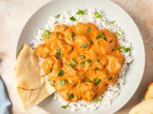 Butter Chicken served with fluffy naan and a side of rice.